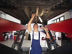 Dieses Bild zeigt einen Mechaniker der ein Auto auf der Hebebühne begutachtet
